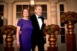 Nancy Pelosi in a purple gown and her husband Paul in a tux 