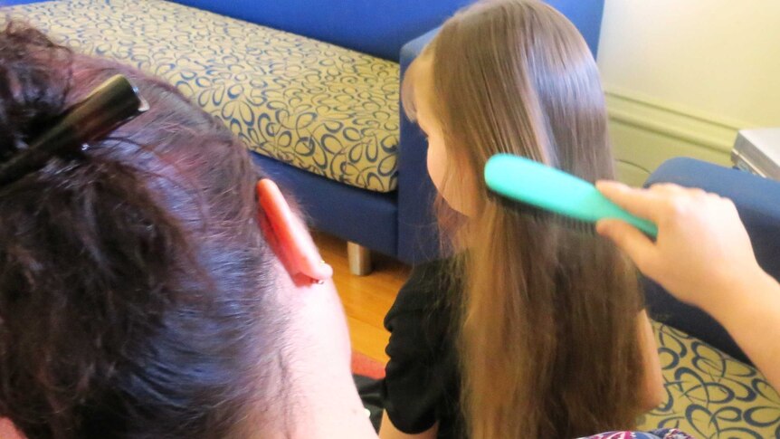 Regan Koczorowski brushing daughter Mia's hair.