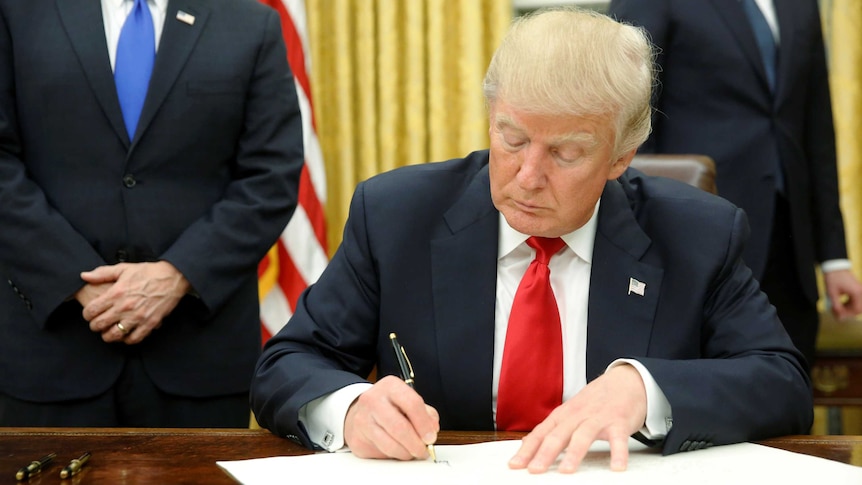 US President Donald Trump signs his first executive orders.