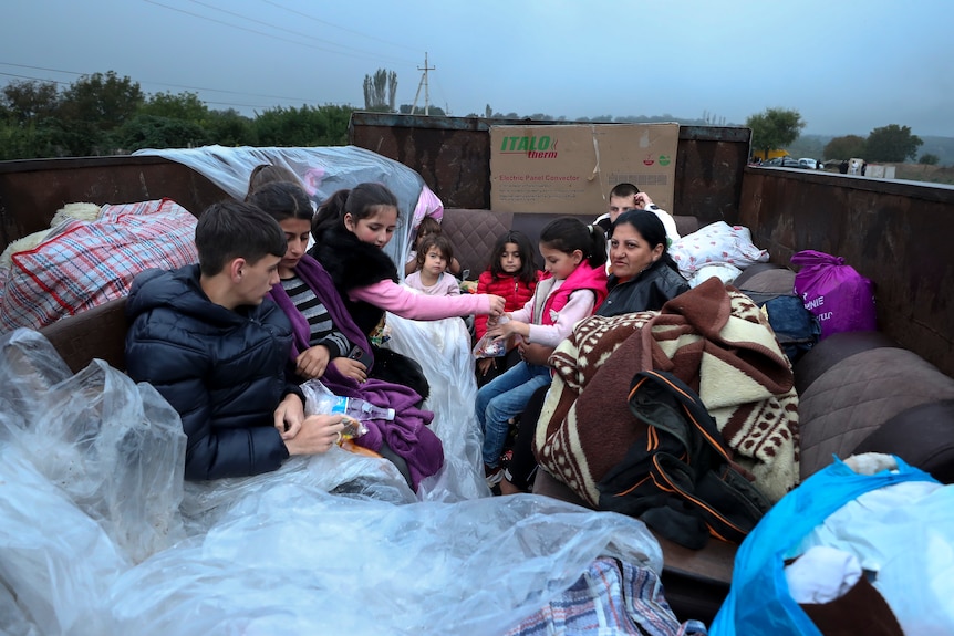 Ethnic Armenians from Nagorno-Karabakh sit in a truck on their way to Armenia.