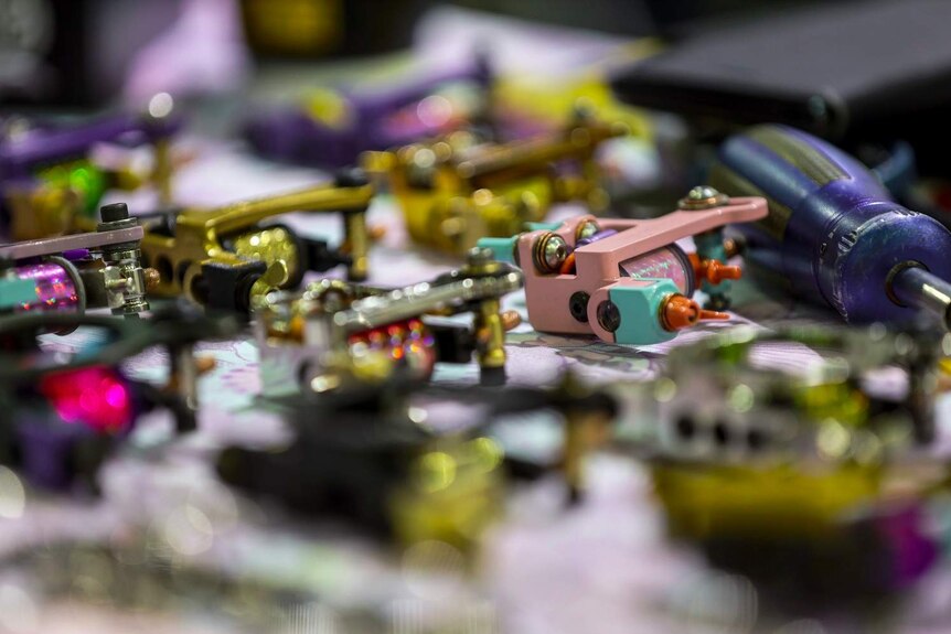 Tattoo guns lie on a table at an expo in Brisbane
