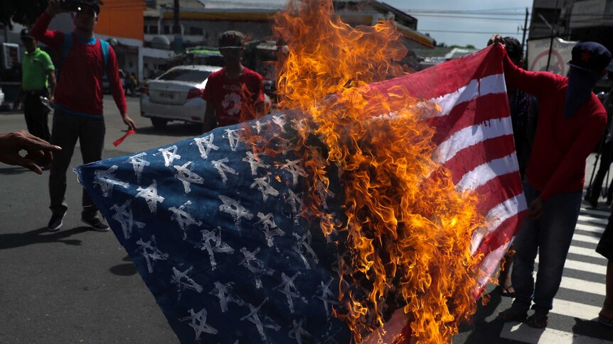 Protesters burn a homemade US flag.