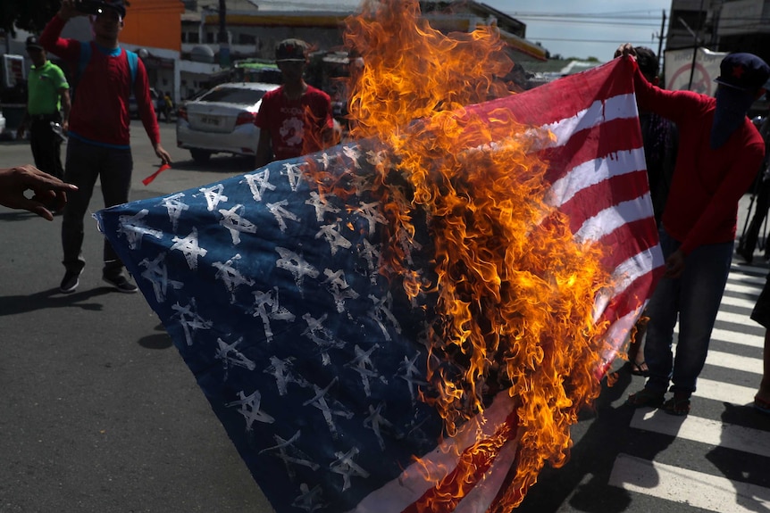 Protesters burn a homemade US flag.