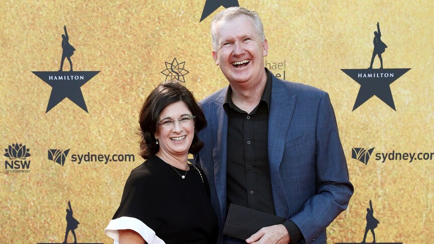 A middle-aged couple stand on the Hamilton red carpet
