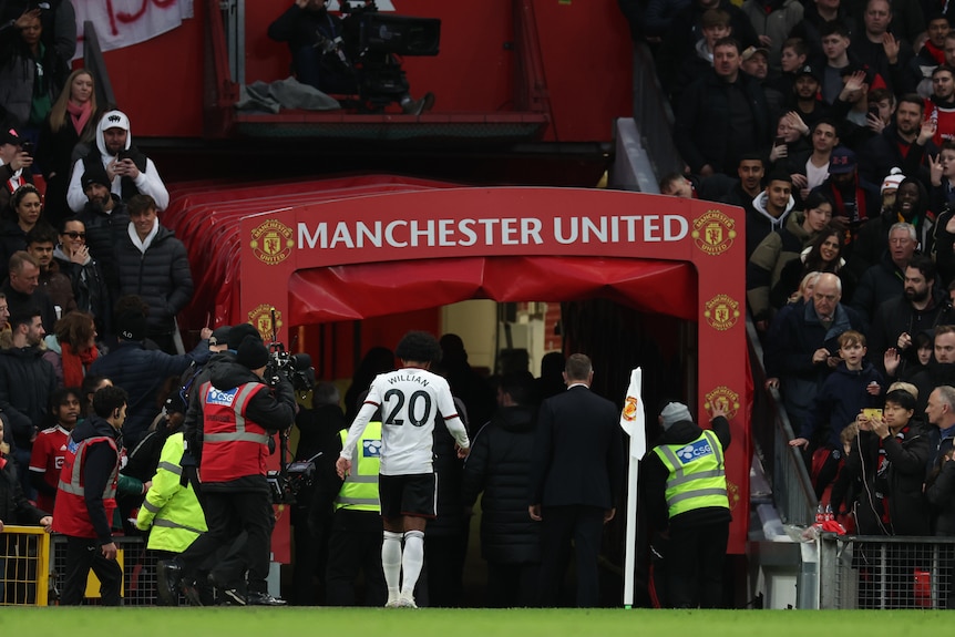 A player's shirt, reading "Willian 20", can be seen as the footballer walks through a tunnel with the Manchester United logo.