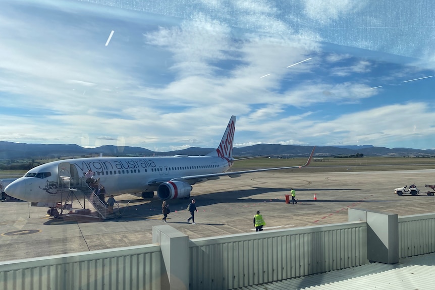 A Virgin plane on a tarmac at a small regional airport