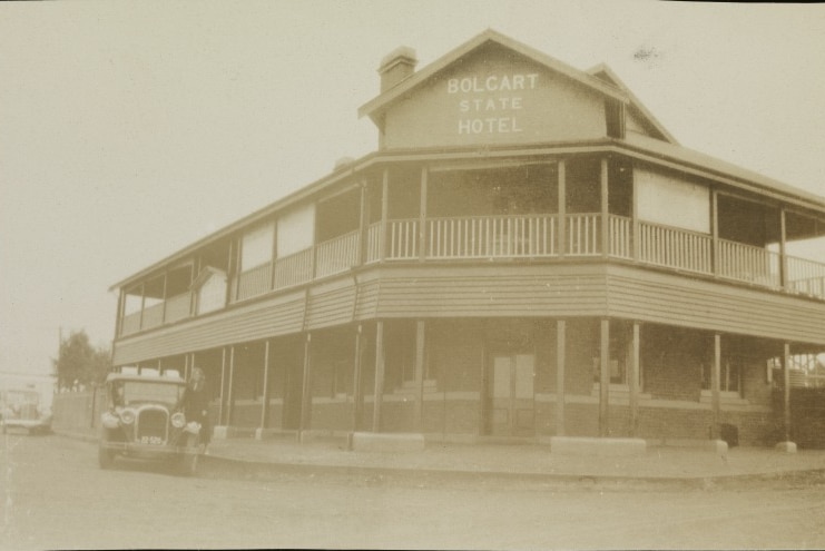 A historical sepia-toned image of an old double-story country hotel.