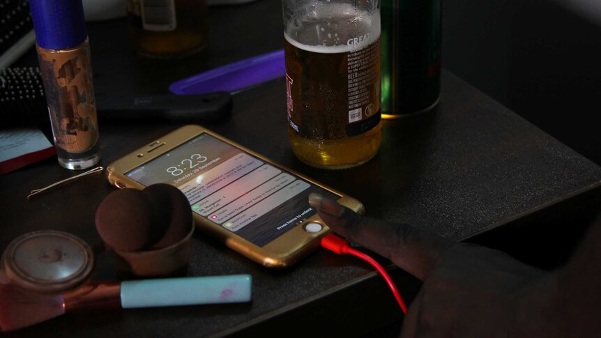 A photo of a phone being activated next to a half-drunk bottle of beer.