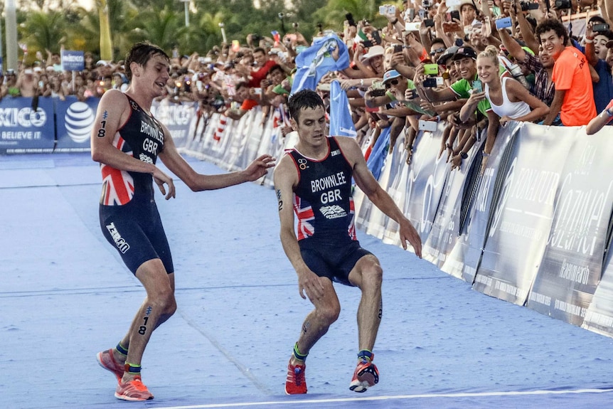 Alistair Brownlee helps his brother Jonathan Brownlee