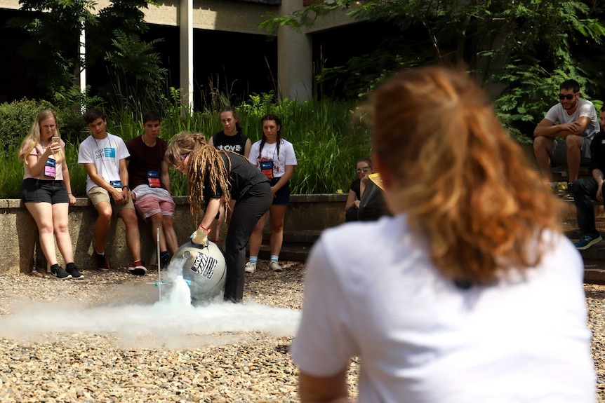 Anna watches scientists from Questacon perform an experiment with liquid nitrogen