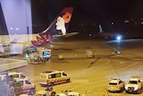 ambulances on a tarmac next to an airplane