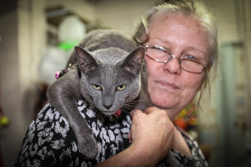 Woman with grey cat on shoulder