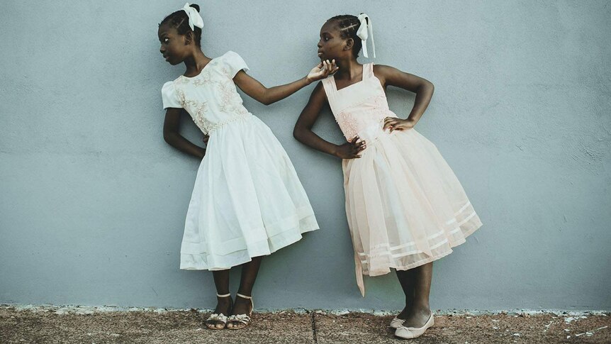 Twin sisters Leida and Laelle wear pastel colours as they pose together against a wall in Brazil