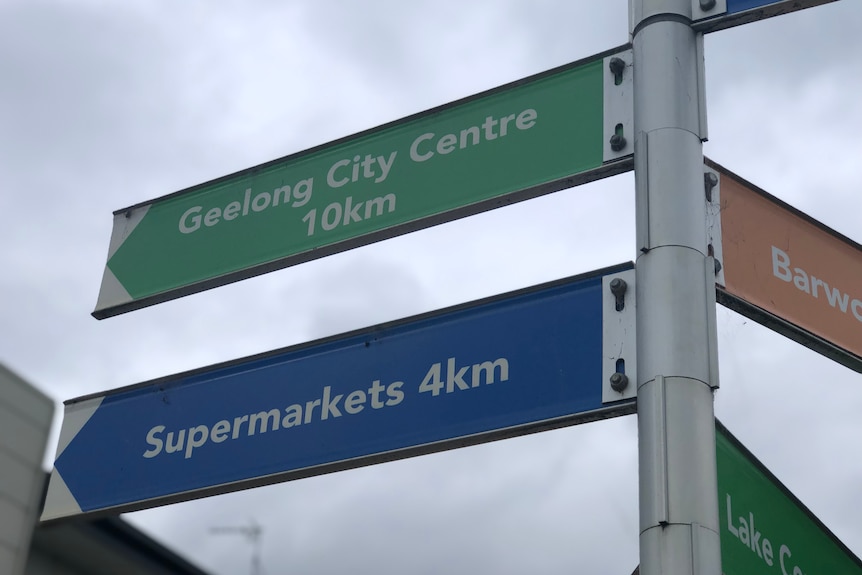 A sign showing distance to Geelong and supermarkets in kilometres.