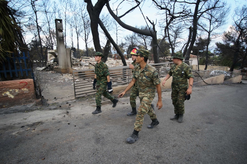 Soldiers on the streets of Mati in the wake of the devastating fire that killed dozens of people.