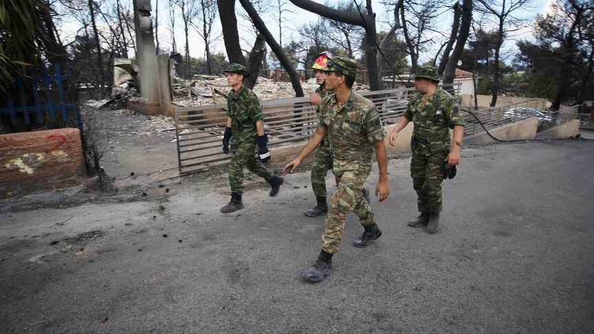 Soldiers on the streets of Mati in the wake of the devastating fire that killed dozens of people.