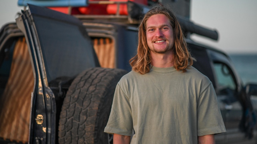 Man stands in front of a car