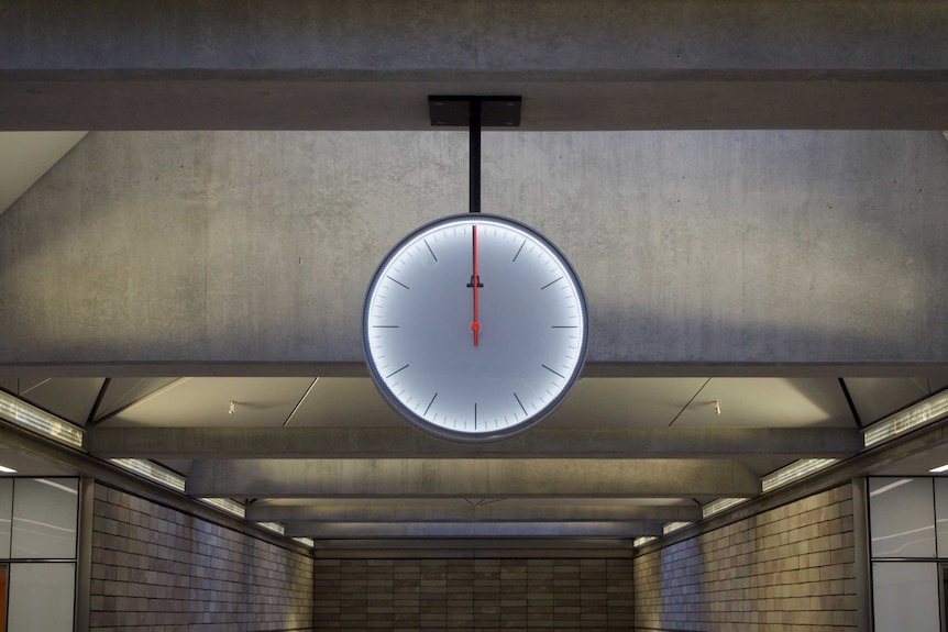 A clock strikes 12:00 at a railway station in Copenhagen.