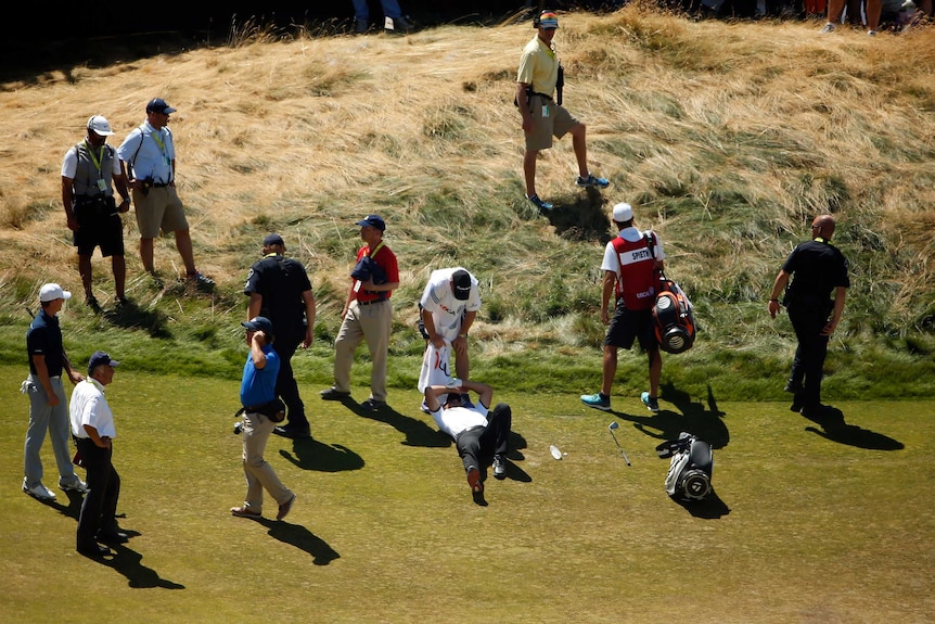 Australia's Jason Day lays on the ninth hole at the US Open after being overcome by dizziness.