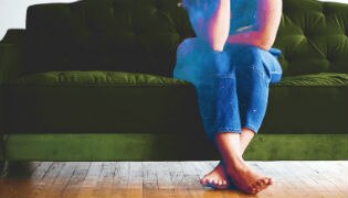 An unidentified woman sits on a green couch