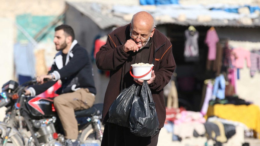 A man eats food that was distributed as aid in a rebel-held besieged area in Aleppo, Syria November 6, 2016.