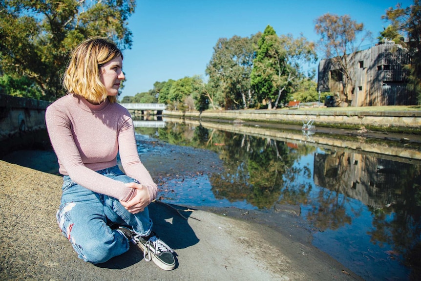 Kit Richards sits by the water.