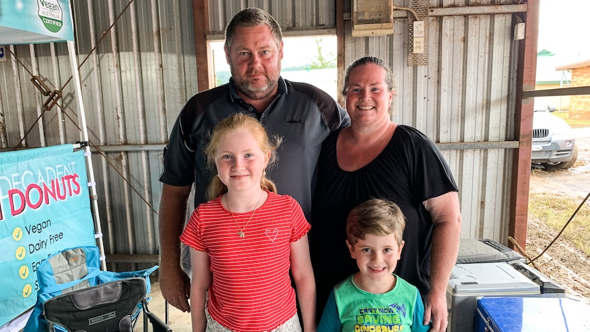 Phillip Partridge and his family stand together behind a market stall.