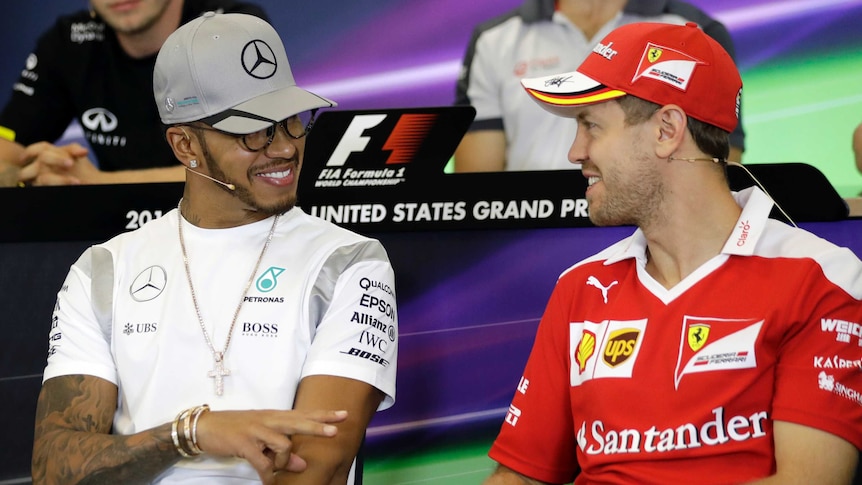 Lewis Hamilton (L) talks to Sebastian Vettel at a press conference ahead of 2016 US F1 grand prix.