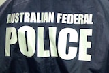 Two unidentified people wearing jackets with "Australian Federal Police" and "Forensics" on the back.