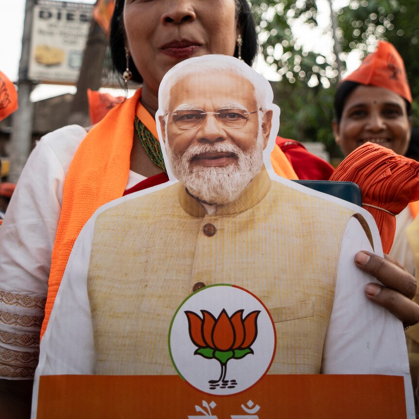 woman holding a poster of Narendra Modi in India