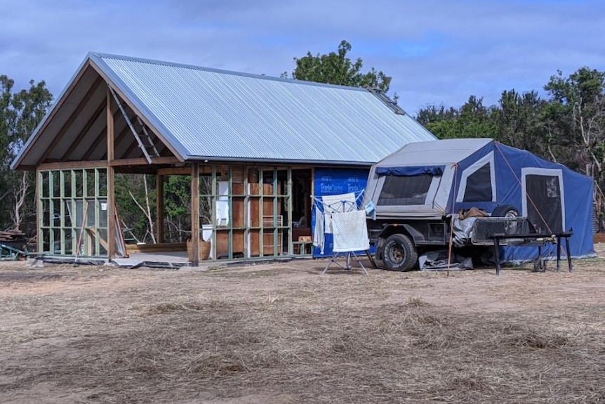 House being built with camper trailer parked outside.