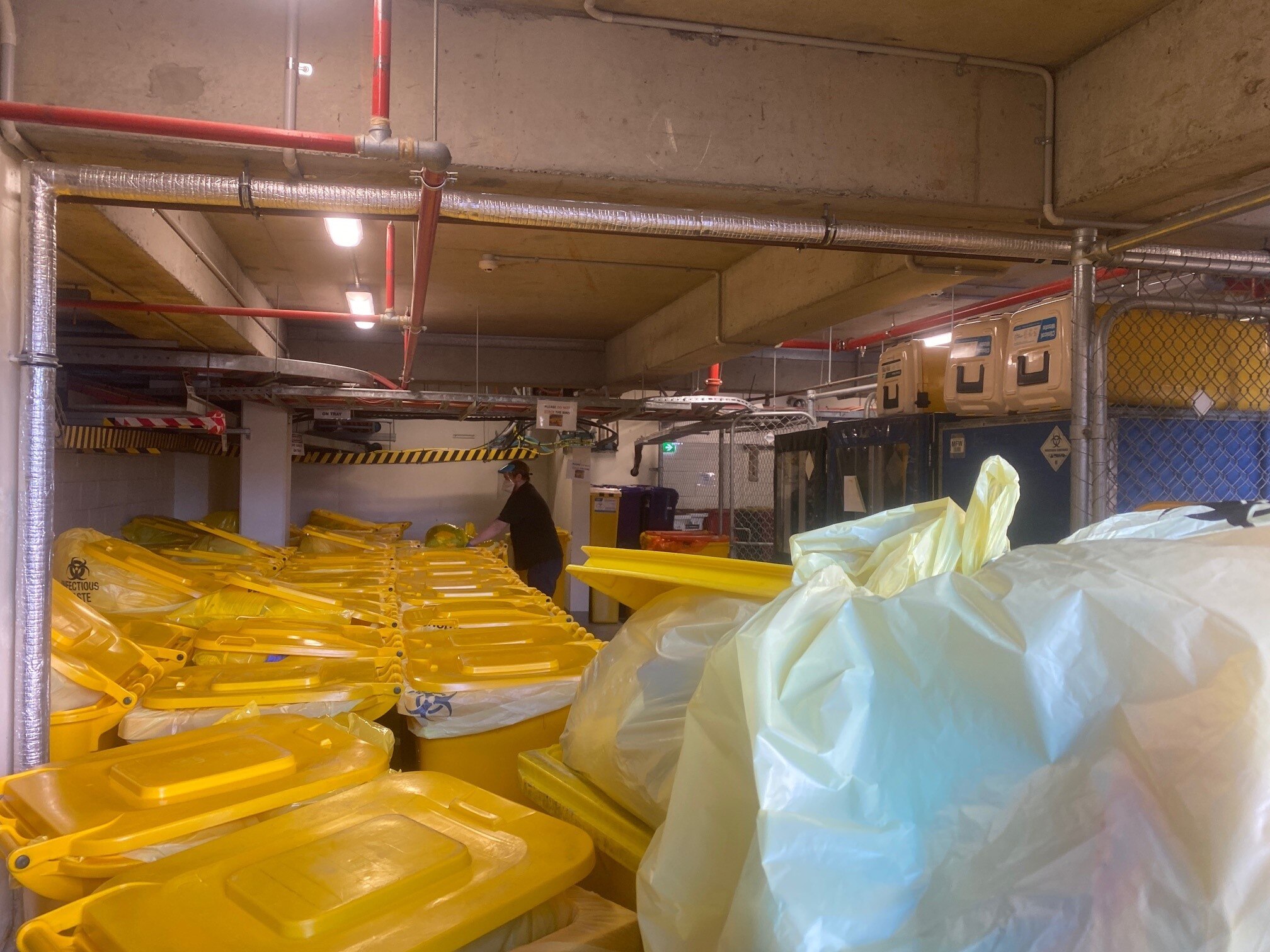 A worker appears to sort out clinical waste in the basement of Sunshine Hospital in Melbourne.