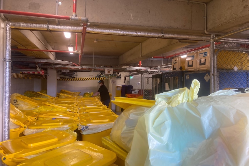 A worker appears to sort out clinical waste in the basement of Sunshine Hospital in Melbourne.