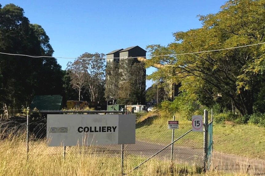 A mine site with a sign on a fence saying "colliery".
