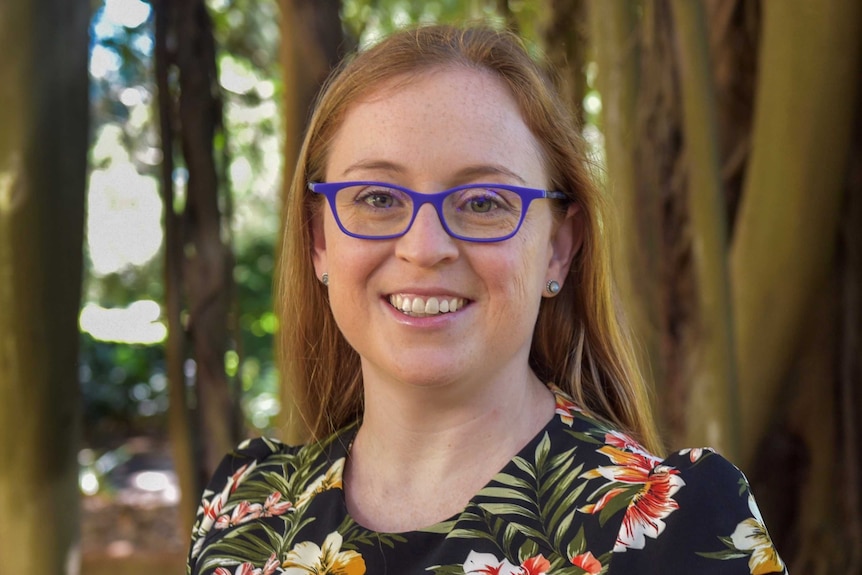 a woman with red hair and blue glasses