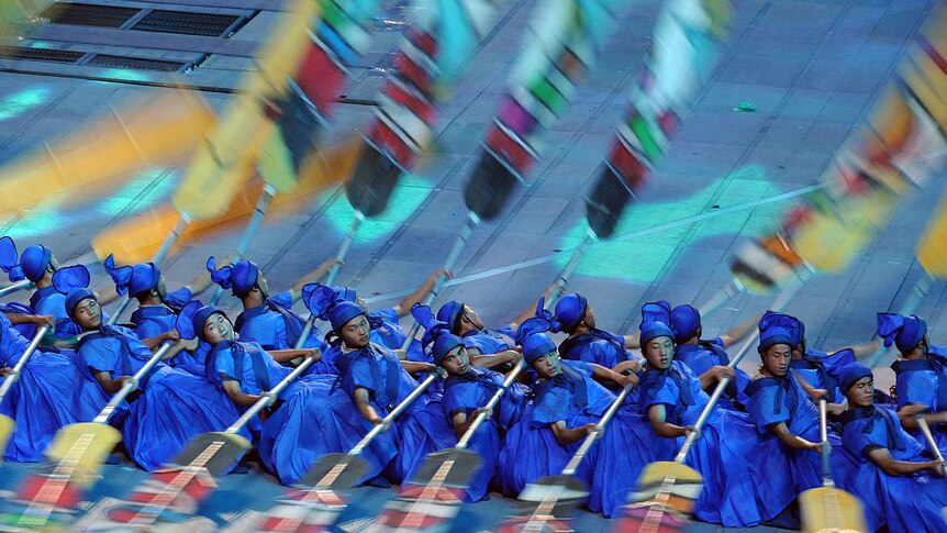 Dozens of men dressed in blue row in the 2008 Beijing Olympics opening ceremony.