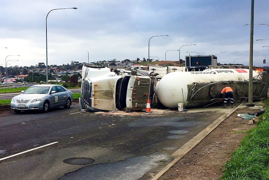 A truck carrying concrete powder lies on its side