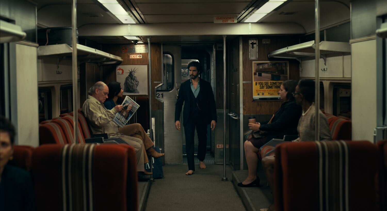 A bearded man in bare feet marches through a subway carriage in Madame Web.