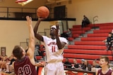 South Sudanese man playing basketball in an American college.