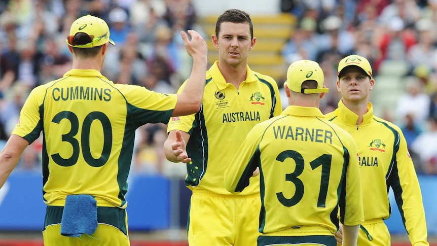 Australia's Josh Hazlewood high-fives two of his teammates during the ICC Champions Trophy match between Australia and NZ.