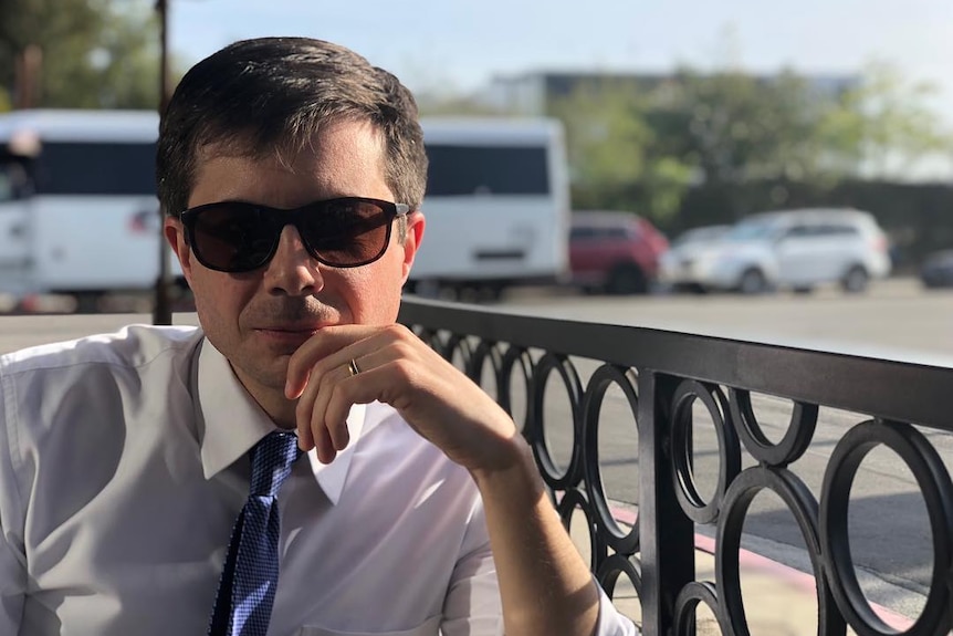 Pete Buttigieg wearing sunglasses while dressed in a shirt and tie