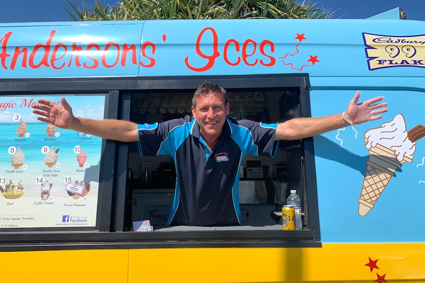 Ice cream vendor Neil Anderson  smiling, leaning out the window of his work van with arms outstretched