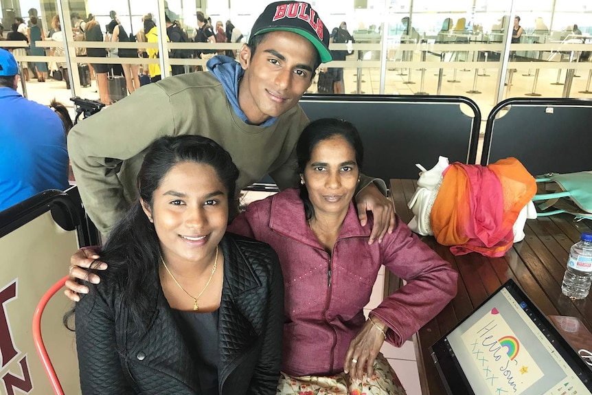 Asylum seeker Soumi Gopalakrishnan sits with her mother and brother at Brisbane Airport.