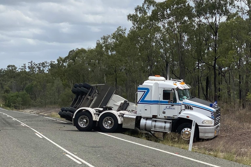 a truck in a ditch along a rural road