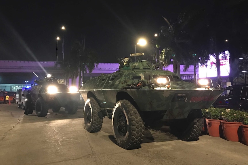 Military vehicles are positioned outside the Resorts World Manila complex.