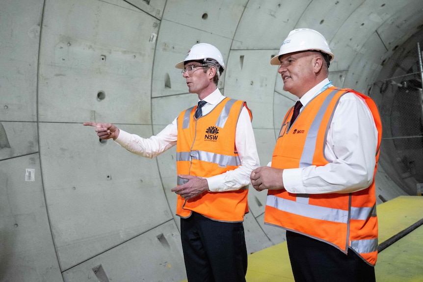 two men walking inside a tunnel and talking