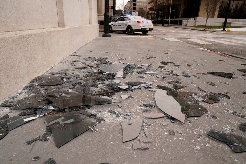 Broken window glass on the footpath near a police car after an explosion in Nashville.