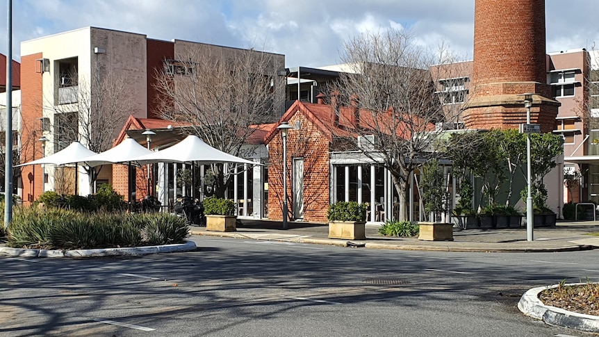 A restaurant with outdoor umbrellas and a large red chimney behind