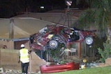 Crane lifts crumpled wreck of crashed car from Thornlie house