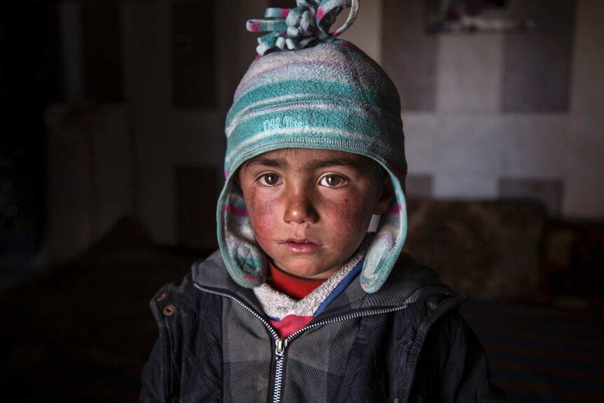 Syrian child Saeed inside an abandoned petrol station.